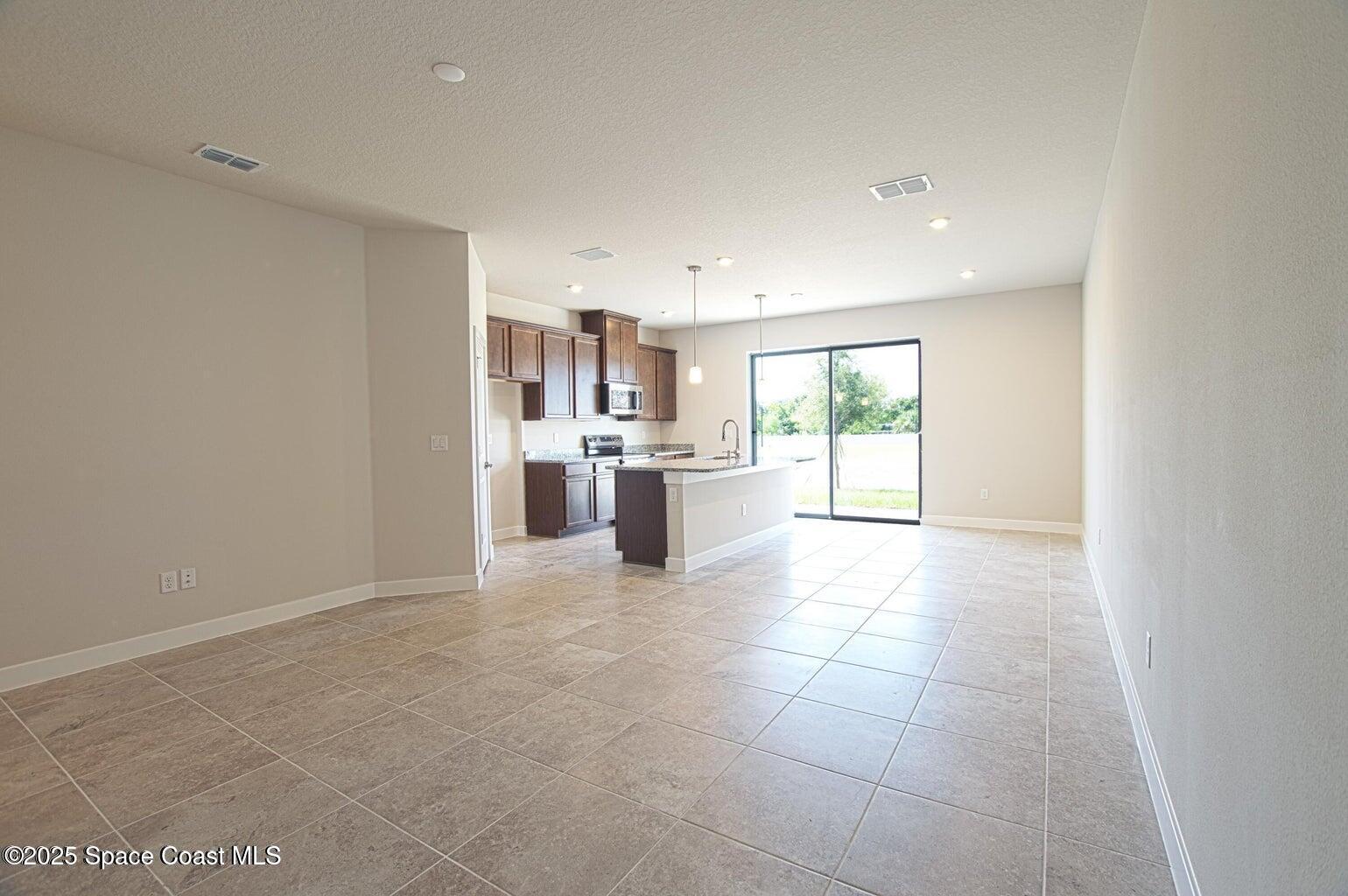 1865 Kendall Pointe Place Melbourne, FL 32935 - Photo 7 of 15 a view of a kitchen with a sink and an empty room