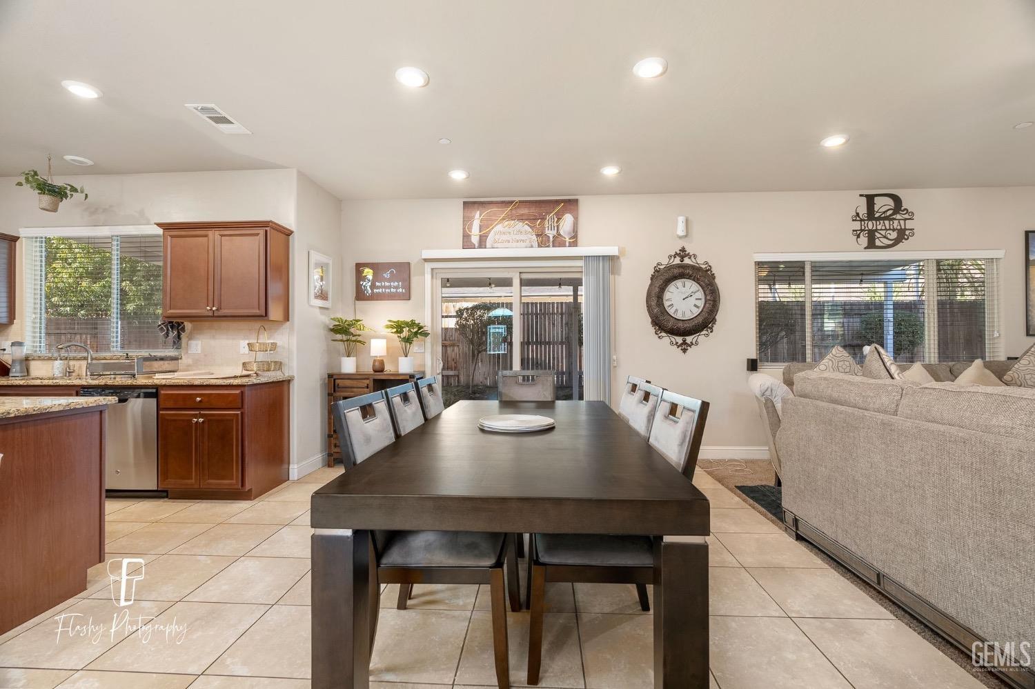 Undisclosed Address Bakersfield, CA 93313 - Photo 14 of 36 a open dining room with stainless steel appliances granite countertop a stove a sink a dining table and chairs
