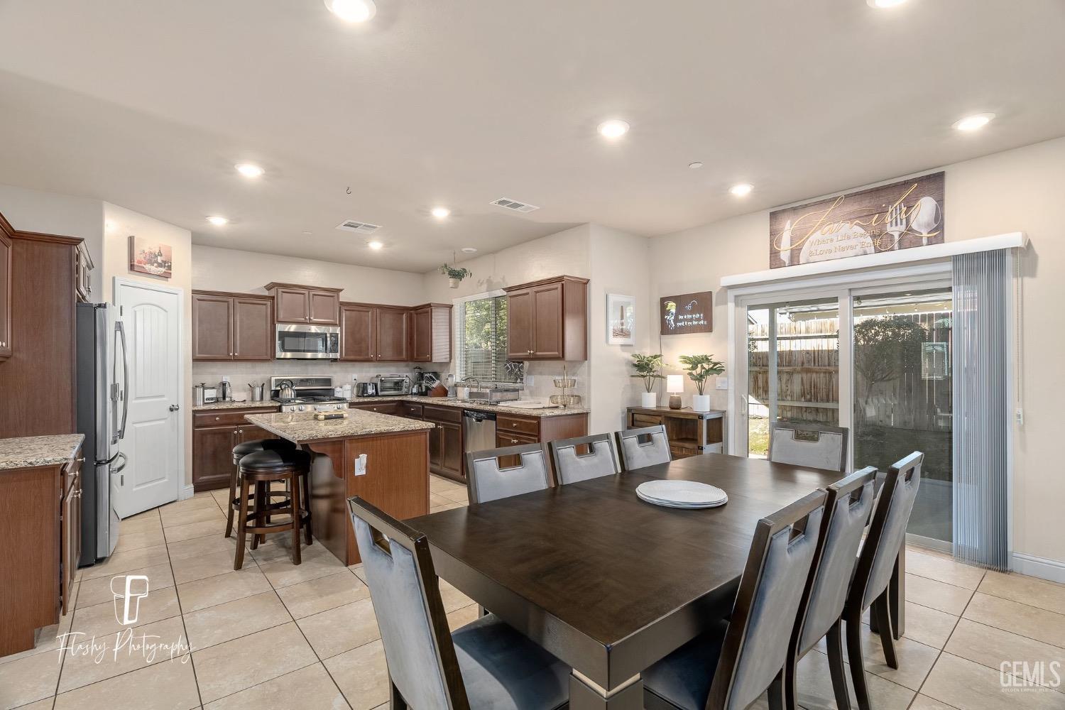 Undisclosed Address Bakersfield, CA 93313 - Photo 15 of 36 a kitchen with a dining table chairs and refrigerator