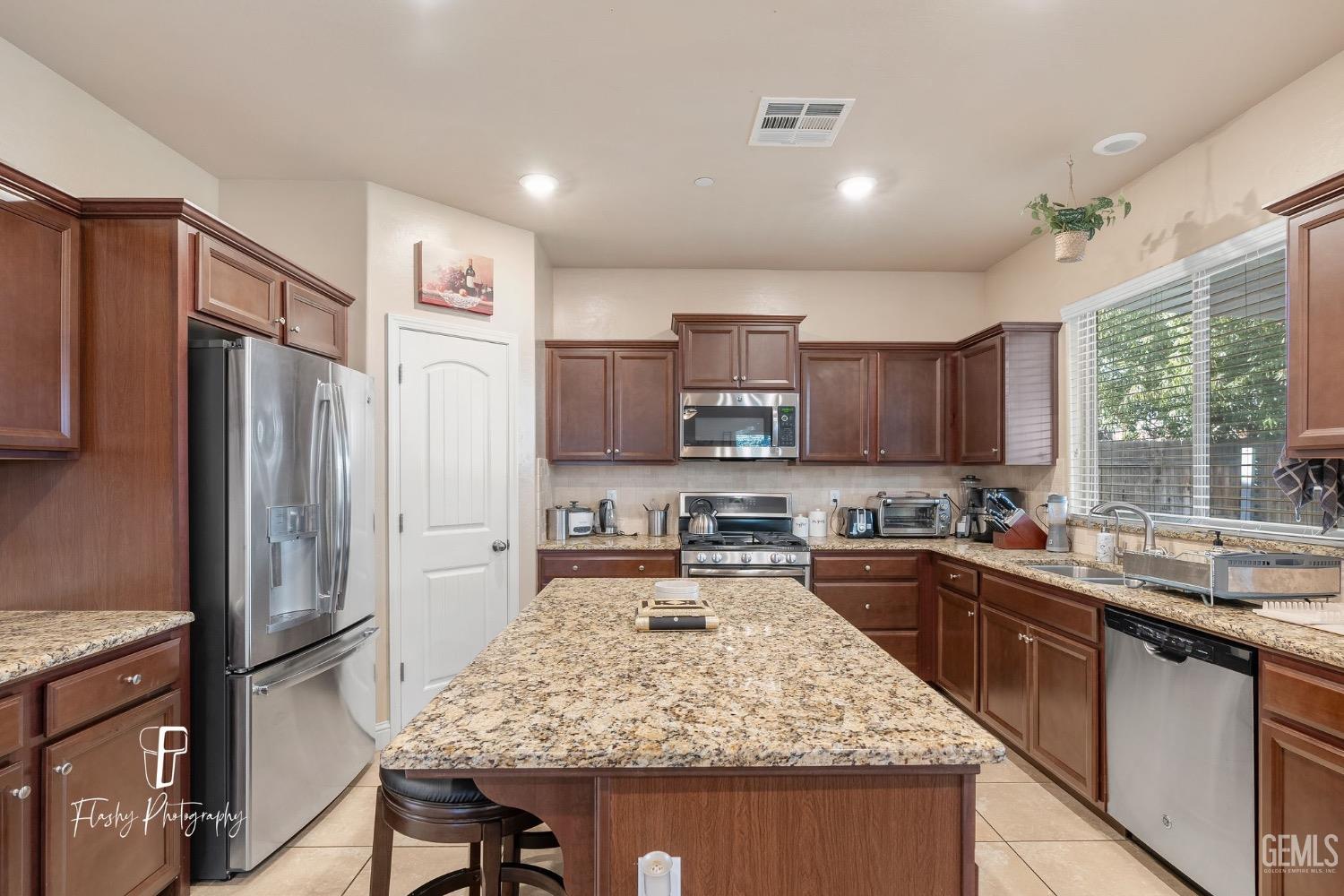 Undisclosed Address Bakersfield, CA 93313 - Photo 16 of 36 a kitchen with stainless steel appliances granite countertop sink stove refrigerator and cabinets