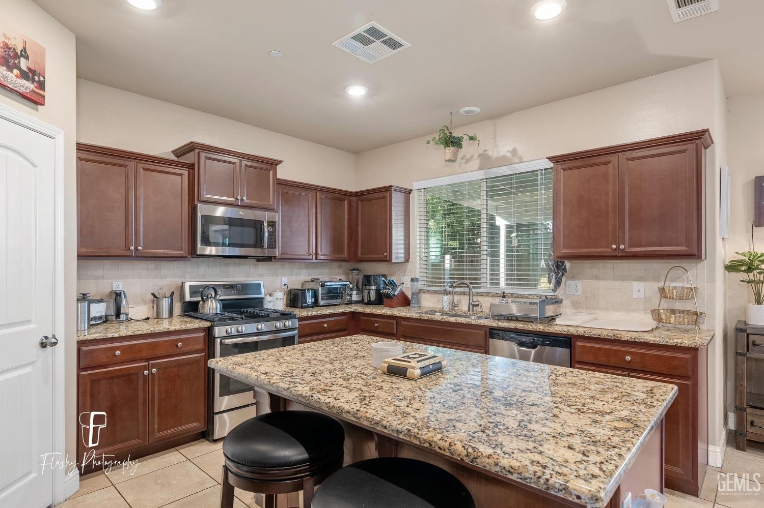 Undisclosed Address Bakersfield, CA 93313 - Photo 17 of 36 a kitchen with a stove a sink and a refrigerator