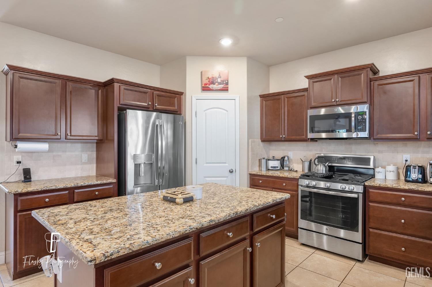 Undisclosed Address Bakersfield, CA 93313 - Photo 18 of 36 a kitchen with stainless steel appliances granite countertop a stove top oven a refrigerator and dishwasher