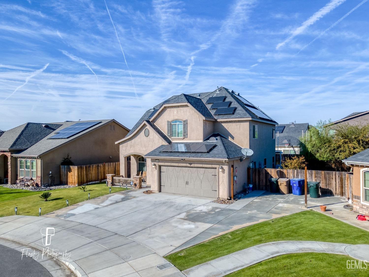 Undisclosed Address Bakersfield, CA 93313 - Photo 2 of 36 a front view of a house with a yard and garage