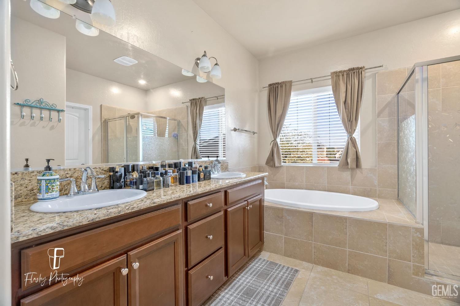 Undisclosed Address Bakersfield, CA 93313 - Photo 30 of 36 a spacious bathroom with a granite countertop sink a toilet a mirror and shower
