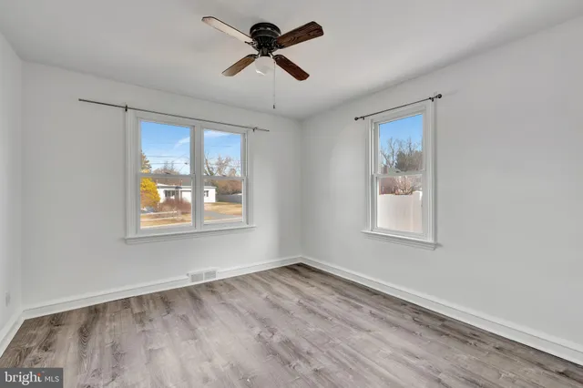 a view of a room with wooden floor and ceiling fan