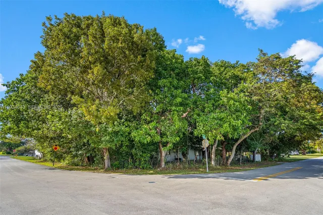 an aerial view of residential houses with outdoor space and trees