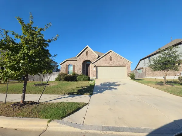 a view of a white house with a yard and large tree