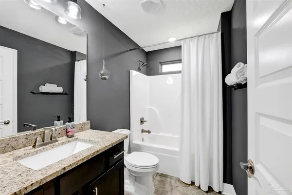 a bathroom with a granite countertop sink toilet and shower