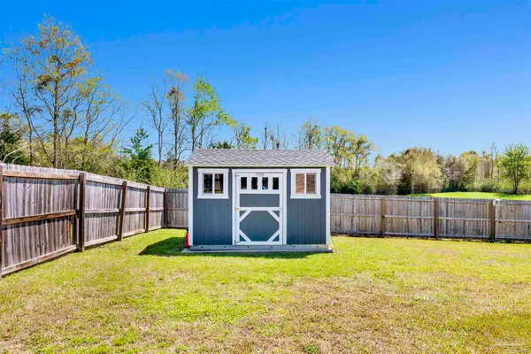 a view of a backyard with a tub and wooden fence
