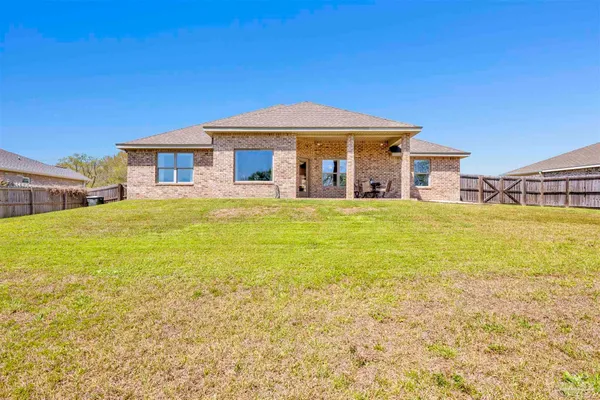 a view of a house with pool and a yard