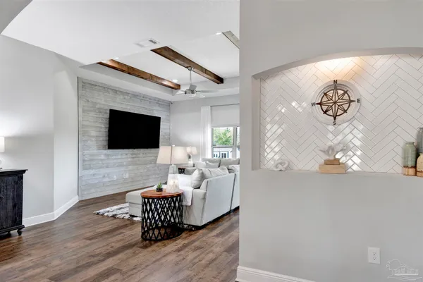 a living room with furniture wooden floor and a flat screen tv
