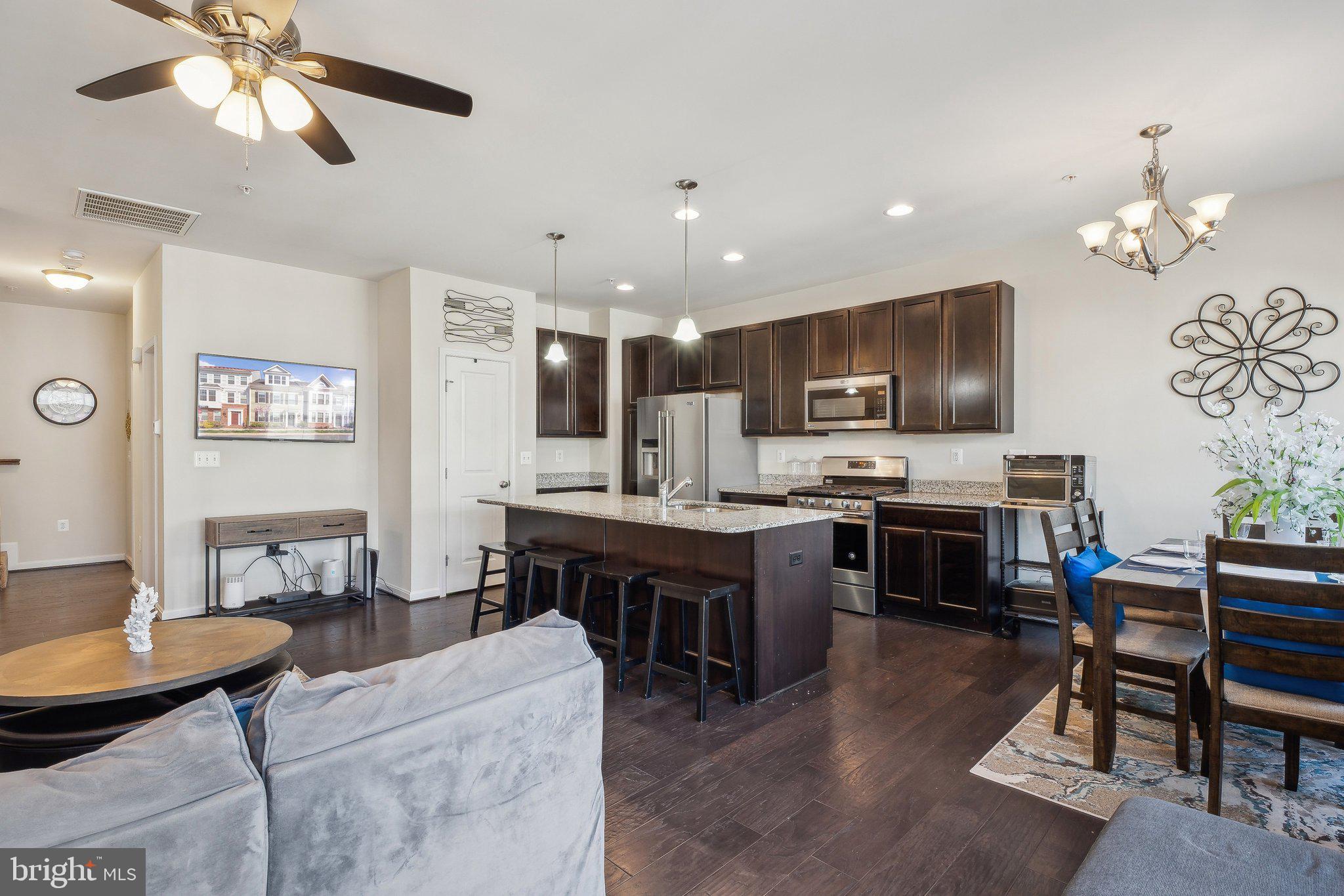 58 Mustang Drive La Plata, MD 20646 - Photo 10 of 42 a kitchen with stainless steel appliances granite countertop a stove top oven a sink a dining table and chairs with wooden floor