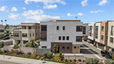 a view of a white building among the street with palm trees