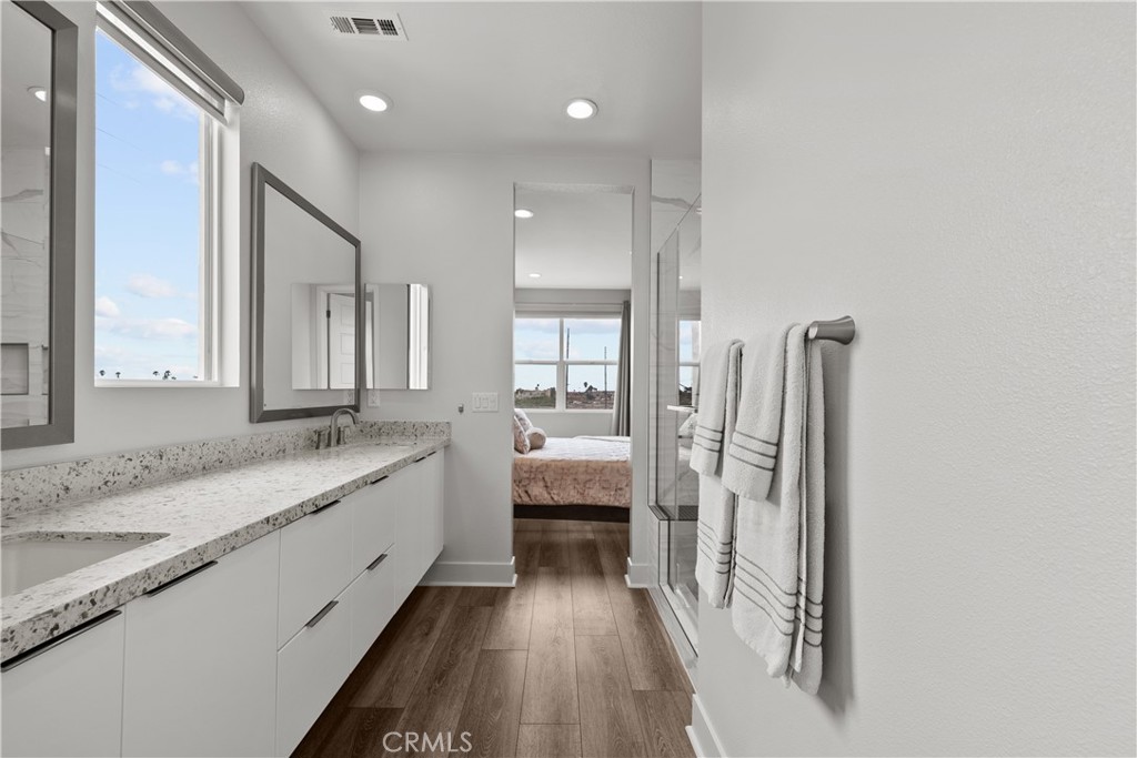 1068 Canal Street Oxnard, CA 93035 - Photo 21 of 36 a bathroom with a granite countertop sink a toilet a mirror and shower