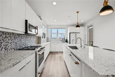 a kitchen with stainless steel appliances granite countertop sink stove and cabinets