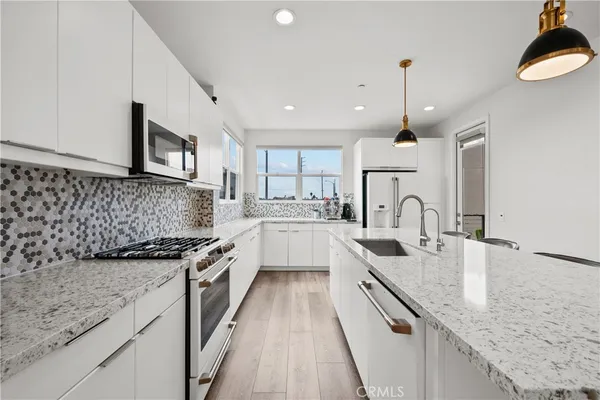 a kitchen with stainless steel appliances granite countertop sink stove and cabinets