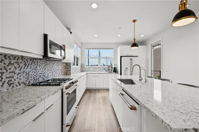 a kitchen with stainless steel appliances granite countertop sink stove and cabinets