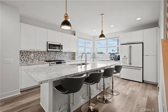 a kitchen with a sink a microwave a refrigerator and cabinets