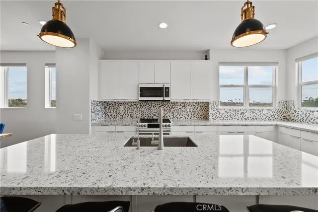 a kitchen with granite countertop a sink a stove and a microwave