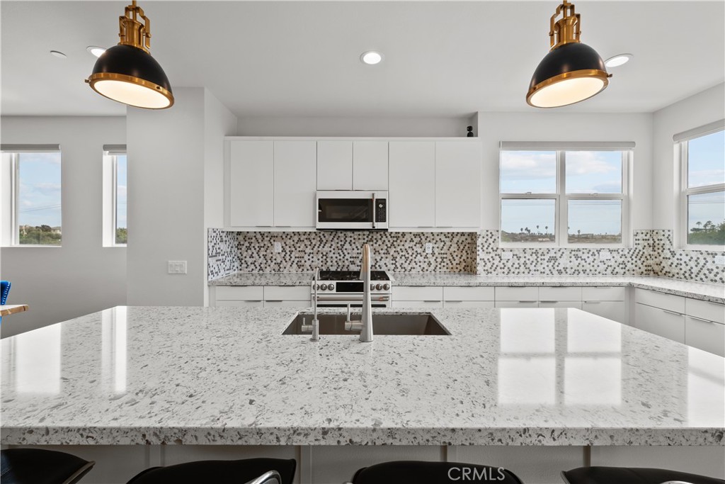 1068 Canal Street Oxnard, CA 93035 - Photo 10 of 36 a kitchen with granite countertop a sink a stove and a microwave
