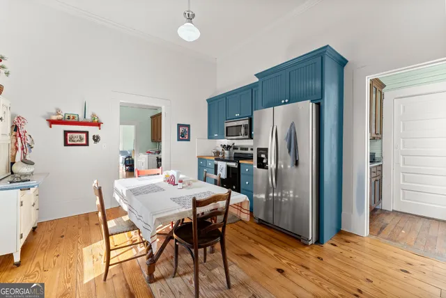 a kitchen with stainless steel appliances a refrigerator and wooden floor