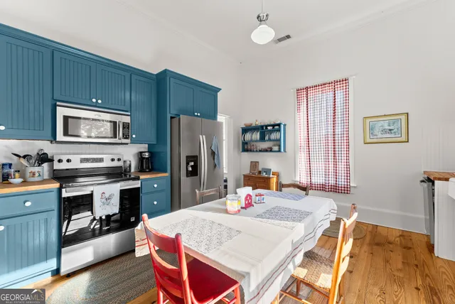 a kitchen with a refrigerator a stove top oven a sink dishwasher and wooden cabinets with wooden floor