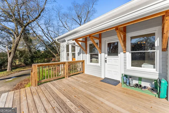a view of a house with wooden deck and furniture