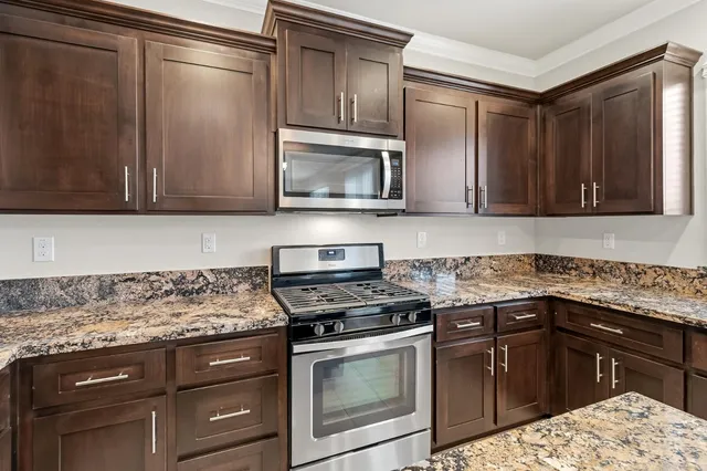 a kitchen with granite countertop a sink cabinets and window