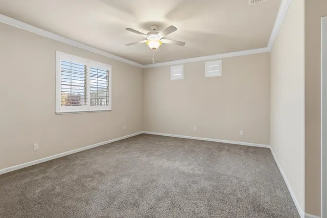 an empty room with windows and fan