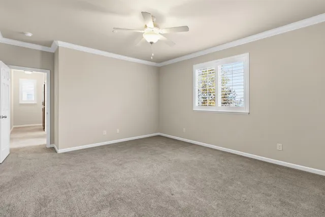 an empty room with a ceiling fan and a window