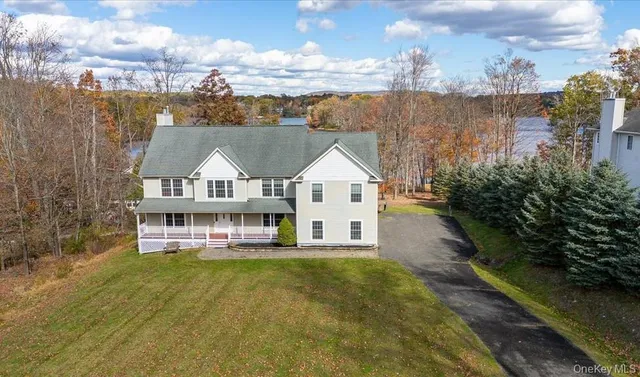 a view of a house with a big yard and large trees