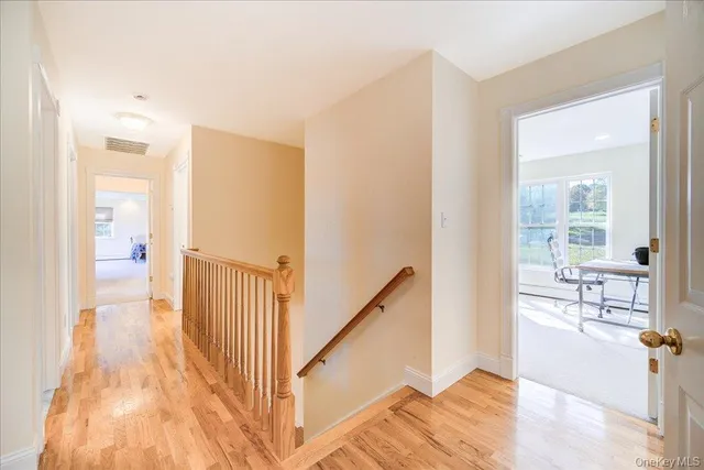 a view of a hallway with wooden floor and furniture