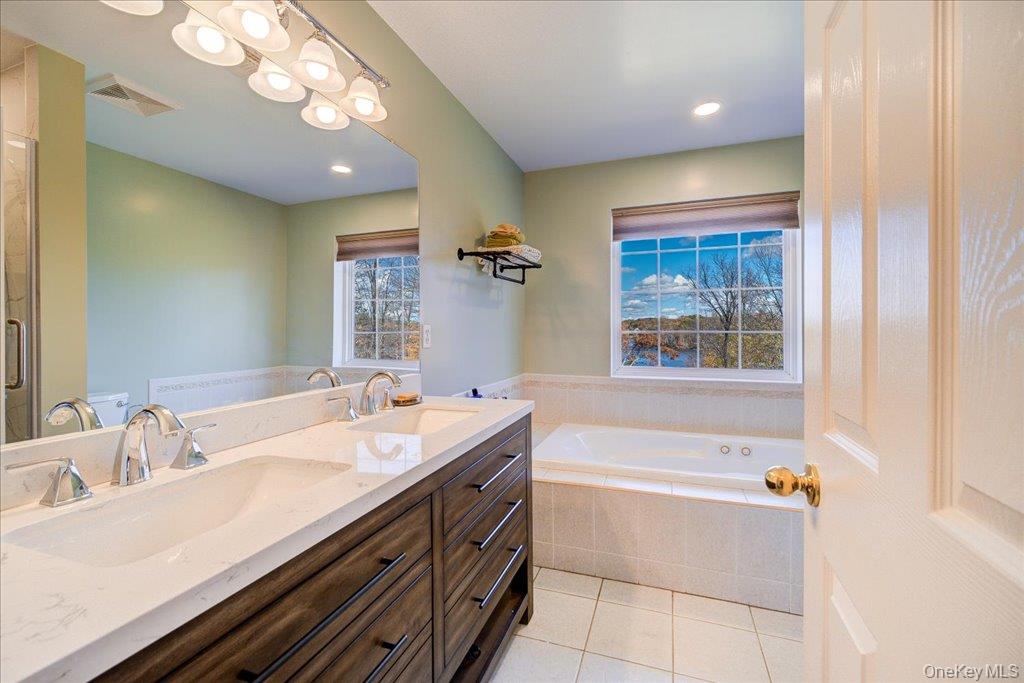 34 Twin Lakes Road Monroe, NY 10950 - Photo 19 of 35 a bathroom with a sink a large mirror and a bathtub