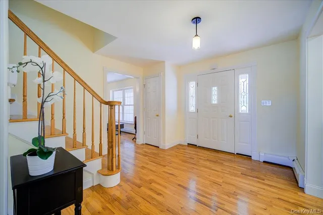 a view of an entryway with wooden floor and a livingroom