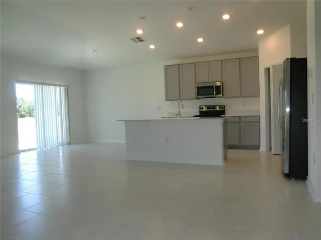 a kitchen with stainless steel appliances a refrigerator and a stove top oven