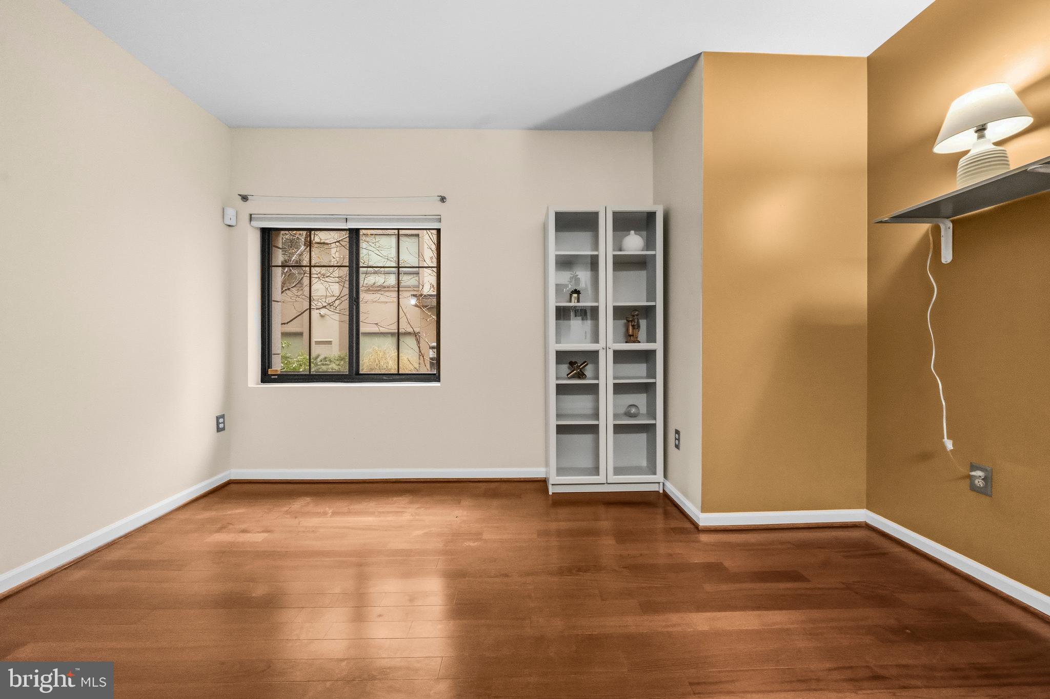 7923 Eastern Avenue Northwest, Unit 105 Silver Spring, MD 20910 - Photo 11 of 32 an empty room with wooden floor and windows
