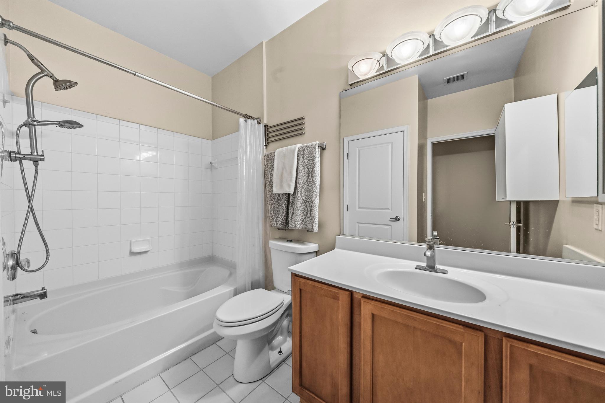 7923 Eastern Avenue Northwest, Unit 105 Silver Spring, MD 20910 - Photo 14 of 32 a bathroom with a sink a toilet and shower