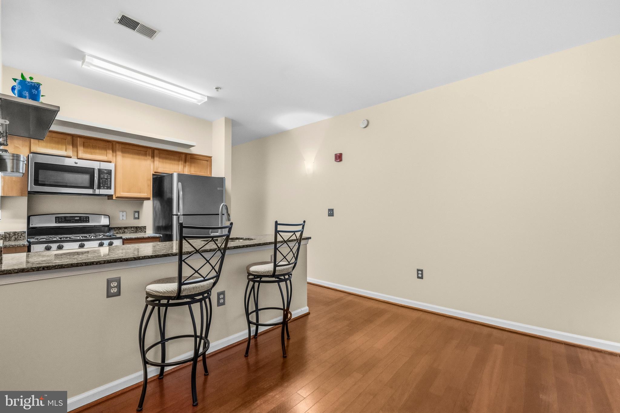 7923 Eastern Avenue Northwest, Unit 105 Silver Spring, MD 20910 - Photo 5 of 32 a kitchen with stainless steel appliances a refrigerator and stove top oven