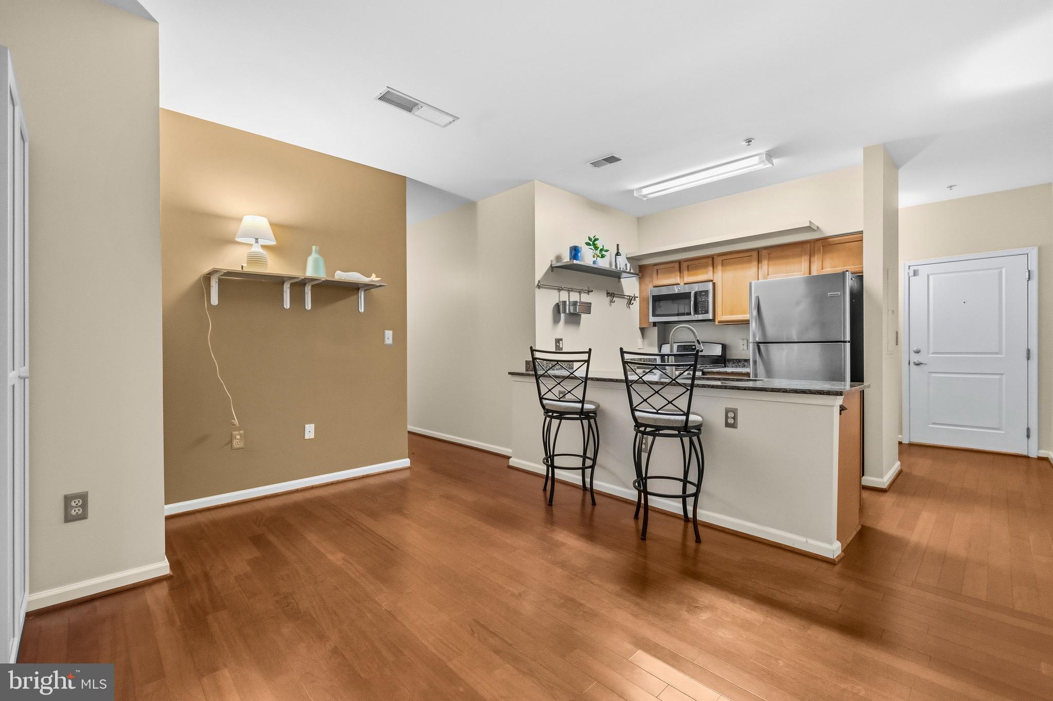7923 Eastern Avenue Northwest, Unit 105 Silver Spring, MD 20910 - Photo 6 of 32 a kitchen with stainless steel appliances a refrigerator and a stove top oven