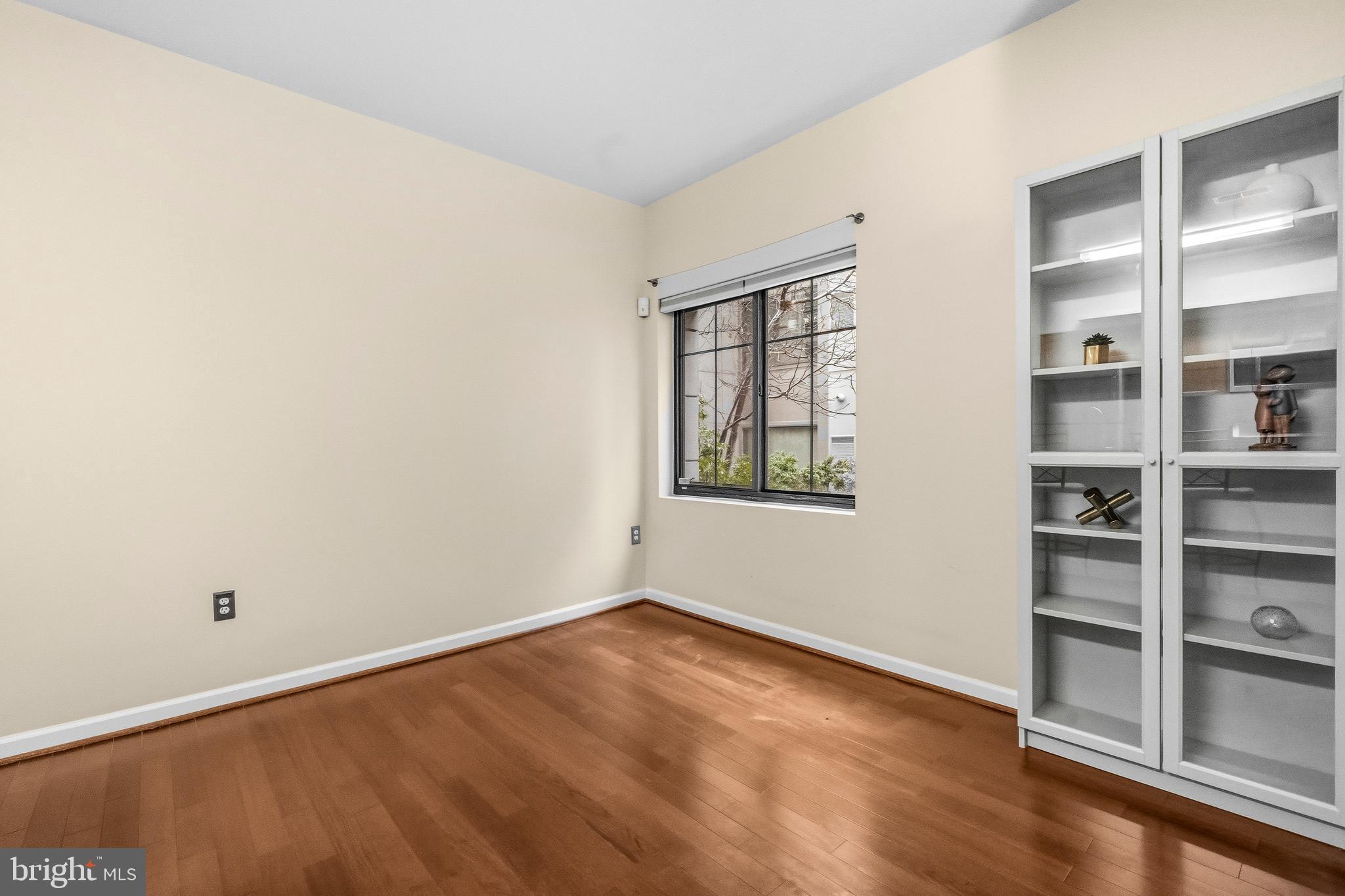 7923 Eastern Avenue Northwest, Unit 105 Silver Spring, MD 20910 - Photo 7 of 32 wooden floor in an empty room with a window