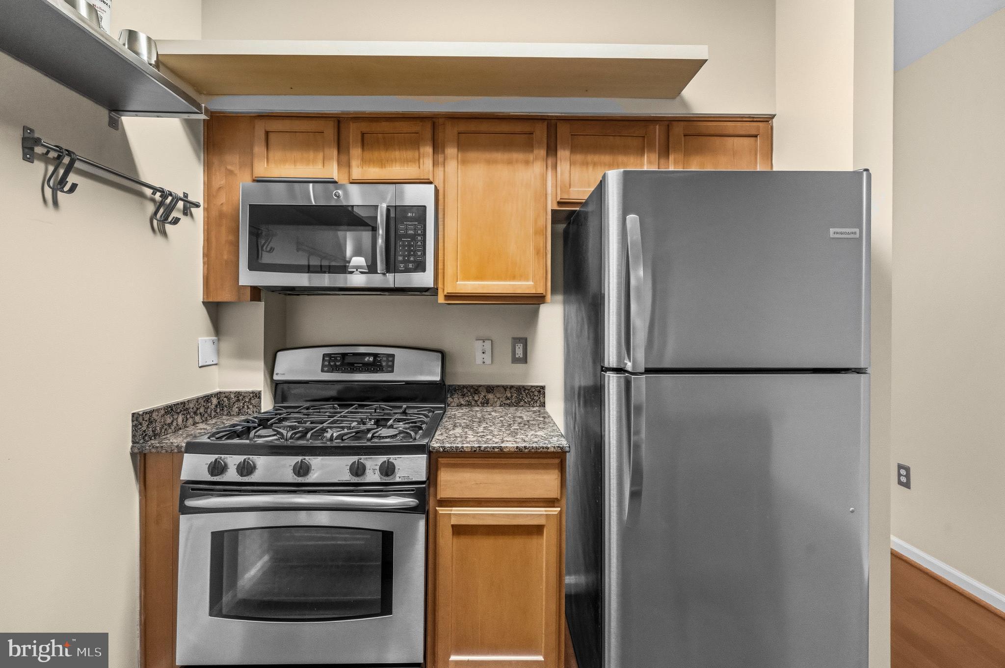 7923 Eastern Avenue Northwest, Unit 105 Silver Spring, MD 20910 - Photo 9 of 32 a kitchen with a refrigerator stove and microwave