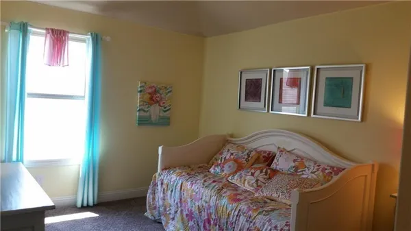 a bed sitting in a bedroom next to a window