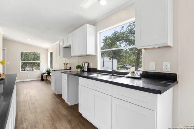 a kitchen with sink a window and cabinets