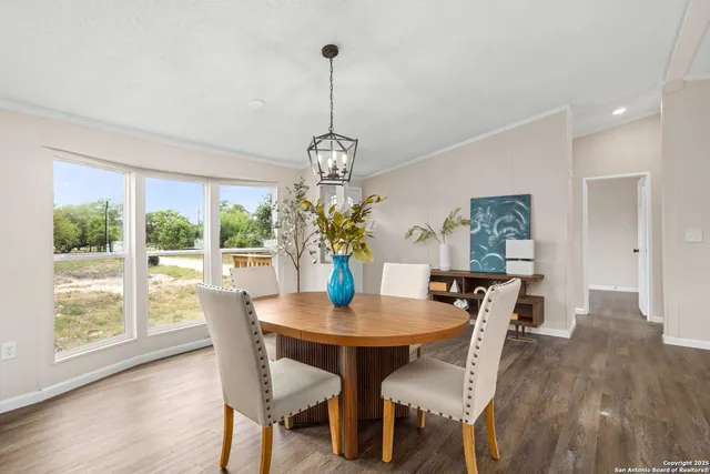 a dining room with furniture a chandelier and wooden floor