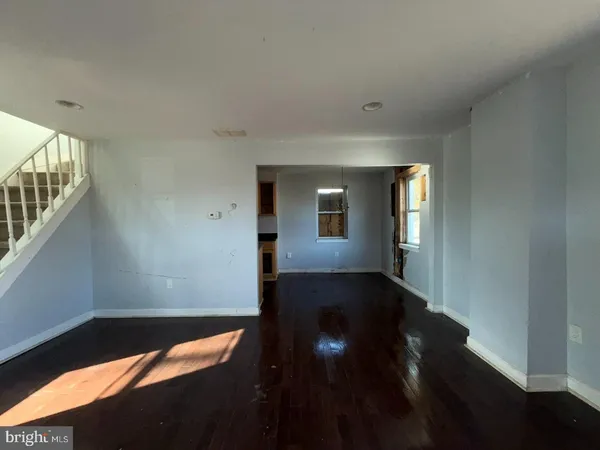 a view of a hallway with wooden floor and a window