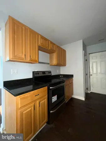 a kitchen with granite countertop a stove a sink and a microwave