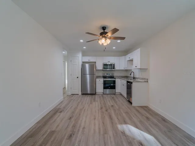 a view of kitchen with refrigerator microwave and stove top oven