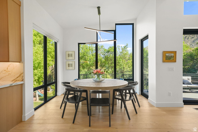 3667 Little Cottonwood Road, Unit 1 Sandy, UT 84092 - Photo 13 of 49 Dining area featuring abundant natural light, light wood-finish flooring, and a modern linear chandelier