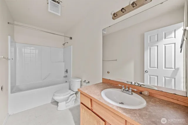 a bathroom with a granite countertop sink a toilet and shower