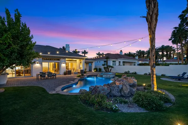 a view of a house with patio and a yard